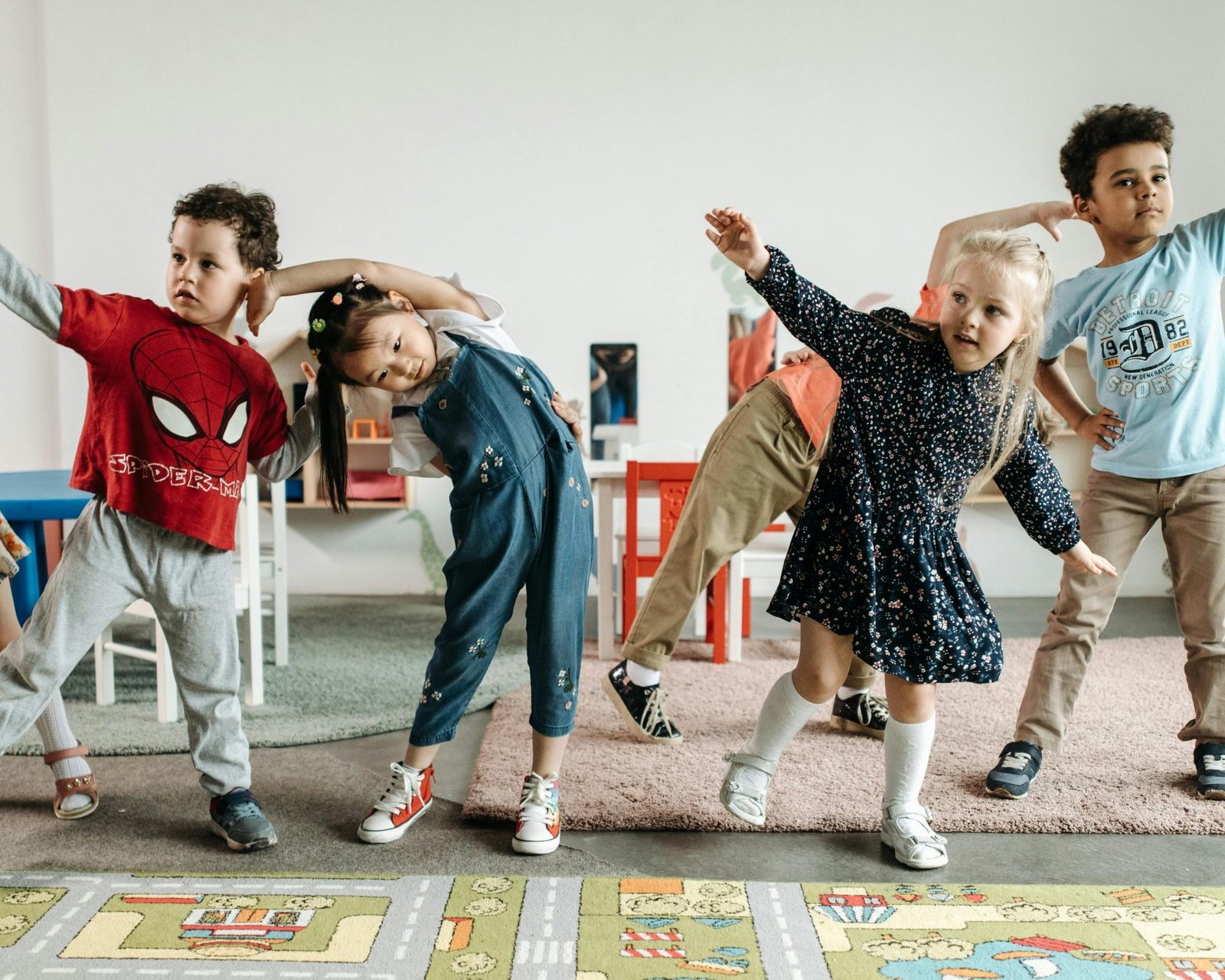 Group of diverse preschool children engaging in fun exercises indoors.